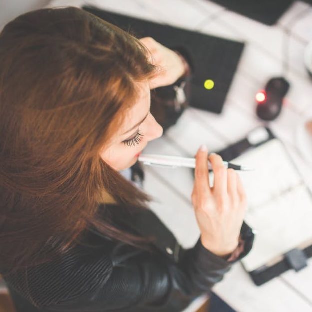 Woman at her office desk thinking over changes in her life, work, values